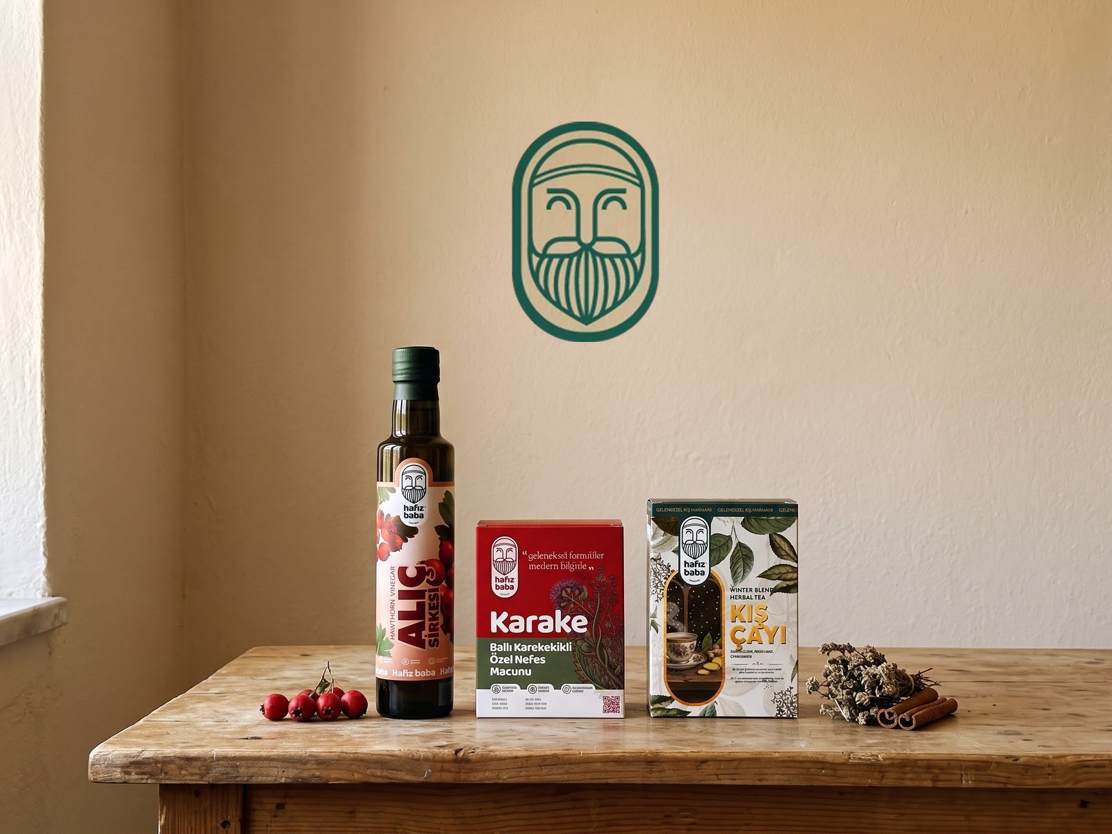 Sıvalı duvar önündeki ahşap tezgâhta dizili Hafızbaba sirke, macun ve çay ürünleri; üstte marka logosu.